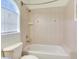 Bathroom with bathtub/shower combination, toilet, and window at 2606 Espana Ct, Tampa, FL 33609