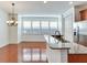 Dining area adjacent to the kitchen with hardwood floors, a chandelier, and large windows with blinds at 2606 Espana Ct, Tampa, FL 33609