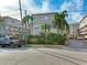 Street view of a townhouse complex with palm trees and a 