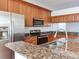 Sleek kitchen with stainless steel appliances, wood cabinets, granite countertops, and a double sink at 2606 Espana Ct, Tampa, FL 33609