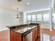 Kitchen with breakfast bar, granite countertops, stainless steel appliances, wood cabinetry, and a chandelier at 2606 Espana Ct, Tampa, FL 33609