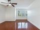 Spacious living area with glossy hardwood floors, white walls, and large windows at 2606 Espana Ct, Tampa, FL 33609