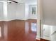 Living room with hardwood floors, ceiling fan, white walls, large windows, and staircase at 2606 Espana Ct, Tampa, FL 33609