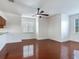 Living room with hardwood floors, white walls, ceiling fan, and multiple windows at 2606 Espana Ct, Tampa, FL 33609