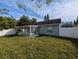 View of the back of the house and yard with white vinyl fencing at 27355 Breakers Dr, Wesley Chapel, FL 33544