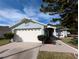 Front exterior of a single-story home with a three-car garage and landscaped yard at 27355 Breakers Dr, Wesley Chapel, FL 33544