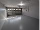 Spacious, empty two-car garage with a gray epoxy floor at 27355 Breakers Dr, Wesley Chapel, FL 33544