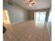 Spacious living room with tiled flooring, ceiling fan, and sliding glass doors to the outdoors at 27355 Breakers Dr, Wesley Chapel, FL 33544