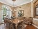 Formal dining room with ornate wood furniture, arched window, and decorative details at 3500 Woodridge Pl, Palm Harbor, FL 34684