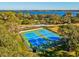 Two blue tennis courts with green fencing in a community area at 3500 Woodridge Pl, Palm Harbor, FL 34684