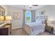 Elegant bedroom with soft gray and white bedding, an iron headboard, and matching nightstands at 3509 Thistle Bank Ct, Plant City, FL 33565