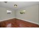 Empty bedroom with polished hardwood floors and two large windows at 3511 Cambridge St, New Port Richey, FL 34652