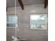 Bright bedroom with whitewashed wood walls, ceiling fan, and windows overlooking water at 370 Pinellas Bayway S # E, Tierra Verde, FL 33715