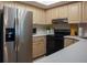 Well-appointed kitchen featuring stainless steel appliances, wood cabinetry, and white countertops at 370 Pinellas Bayway S # E, Tierra Verde, FL 33715