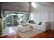 Coastal living room with a white sectional sofa, wood floors, fireplace, and sliding glass doors to a balcony at 370 Pinellas Bayway S # E, Tierra Verde, FL 33715