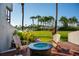 Patio with a fire pit, wooden chairs, and lush landscaping overlooking the marina at 370 Pinellas Bayway S # E, Tierra Verde, FL 33715