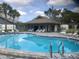 Community pool area with a covered pavilion, lounge chairs, and a fence at 3920 El Camino Ct, Largo, FL 33771