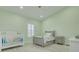 Charming bedroom with light green walls, plantation shutters, a crib, and a toddler bed at 4603 Overlook Ne Dr, St Petersburg, FL 33703