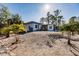 White and gray container home on a landscaped hill with palm trees at 489 Campbell St, Port Charlotte, FL 33953