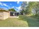 Exterior view of the home showcasing the yard and screened-in back porch at 5624 Mccoy Ct, Zephyrhills, FL 33542