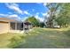 Home's lush backyard with a screened-in porch at 5624 Mccoy Ct, Zephyrhills, FL 33542