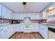 Kitchen with white cabinets, white appliances, and wood-look tile floors at 5624 Mccoy Ct, Zephyrhills, FL 33542