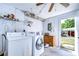 Functional laundry room with appliances, shelving and a door leading outside at 5624 Mccoy Ct, Zephyrhills, FL 33542