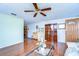 Comfortable living room with glossy hardwood floors, ceiling fan and bright front door at 5624 Mccoy Ct, Zephyrhills, FL 33542
