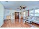 Inviting living room with warm wood flooring, ceiling fan, and plenty of natural light at 5624 Mccoy Ct, Zephyrhills, FL 33542
