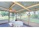 Screened porch with a table, chairs, and ceiling fan, overlooking the backyard at 5624 Mccoy Ct, Zephyrhills, FL 33542