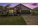 Charming home's exterior at dusk with a two-car garage and landscaping at 6110 162Nd E Ave, Parrish, FL 34219