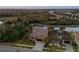 An aerial view of a home next to a pond and surrounded by lush landscaping at sunset at 7183 Heather Sound Loop, Wesley Chapel, FL 33545