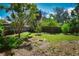 View of the home's well-maintained backyard with mature trees at 9567 85Th St, Seminole, FL 33777