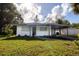 Single-story home with a carport, green grass, and landscaping at 1009 Oakland Heights Ave, Plant City, FL 33563