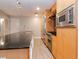 Stylish kitchen with dark granite countertops, stainless steel appliances, and wood cabinets at 1120 E Kennedy Blvd # 927, Tampa, FL 33602
