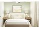 Comfortable bedroom with relaxing green hues, a cozy bed, and simple decor at 12430 Sweet Angel Aura Way, Parrish, FL 34219