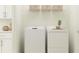 Convenient laundry room with a white washer and dryer, wire shelving, and storage baskets at 12430 Sweet Angel Aura Way, Parrish, FL 34219