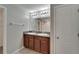 Bathroom vanity with double sinks, brown cabinets, and a large mirror at 12728 Lemon Pepper Dr, Riverview, FL 33578