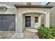 Front entryway with dark gray door, covered porch, and attached two-car garage at 12728 Lemon Pepper Dr, Riverview, FL 33578