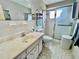 A full bathroom with white tiled walls, decorative shower doors, and a large vanity at 2403 Finlandia Ln # 57, Clearwater, FL 33763
