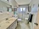 Well-lit bathroom featuring neutral colors, a glass shower door, and vanity with drawer storage at 2403 Finlandia Ln # 57, Clearwater, FL 33763