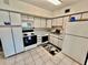 Well-maintained kitchen with white cabinets and appliances, tiled floors and ample countertop space at 2403 Finlandia Ln # 57, Clearwater, FL 33763