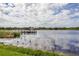 Picturesque lake with a wooden pier, tall grasses, and reflections of the sky at 2403 Finlandia Ln # 57, Clearwater, FL 33763