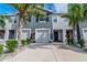 Exterior of a two-story townhome with gray siding, two-car garage, and landscaping at 2922 Suncoast Blend Dr, Odessa, FL 33556