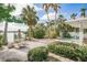 Backyard patio with seating, umbrella, pool, and lush landscaping at 307 10Th Ave, Indian Rocks Beach, FL 33785