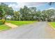 Gravel driveway leading to a gated entrance with a brick walkway and lush green lawns at 4823 Miley Rd, Plant City, FL 33565