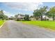 Long gravel driveway leading to a two-story house with a large yard and mature trees at 4823 Miley Rd, Plant City, FL 33565