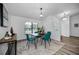 Modern dining space with a live-edge table, teal chairs, and lots of natural light at 520 Meravan Dr, Palm Harbor, FL 34683