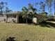 Back view of a house with a screened lanai and landscaping at 5440 Paula St, North Port, FL 34286