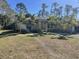 Landscaped front yard of a one-story home with palm trees at 5440 Paula St, North Port, FL 34286